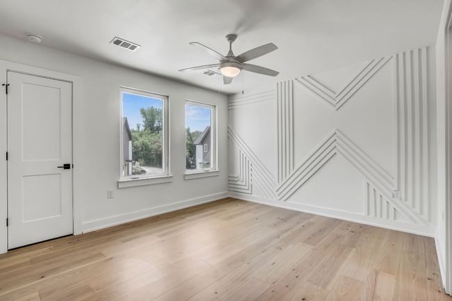 Empty room featuring ceiling fan, a decorative wall, light wood-type flooring, baseboards, and a smoke detector | Image 7