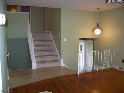 Stairway with hardwood / wood-style flooring and a chandelier | Image 2