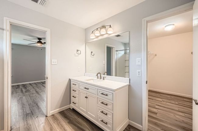 Bathroom featuring vanity, ceiling fan, visible vents, and wood finished floors | Image 16