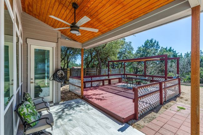 Wooden terrace with outdoor dining area, fence, and a ceiling fan | Image 28