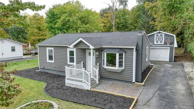 View of front facade featuring a garage and a front lawn | Image 1