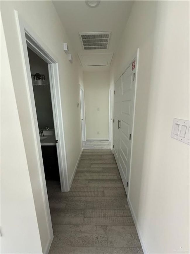 Hall with wood finished floors and baseboards | Image 5