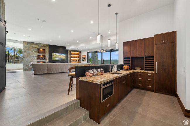 Kitchen featuring a sink, a breakfast bar, pendant lighting, recessed lighting, and plenty of natural light | Image 55