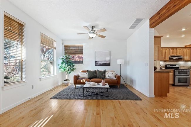 Living room with light wood-style flooring, ceiling fan, and a textured ceiling | Image 17