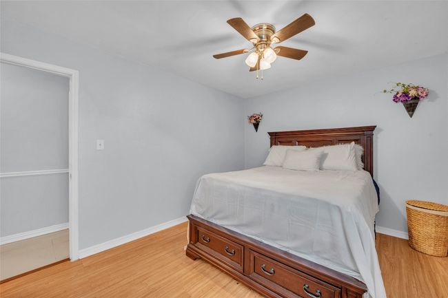 Bedroom with baseboards, a ceiling fan, and light wood-style flooring | Image 15