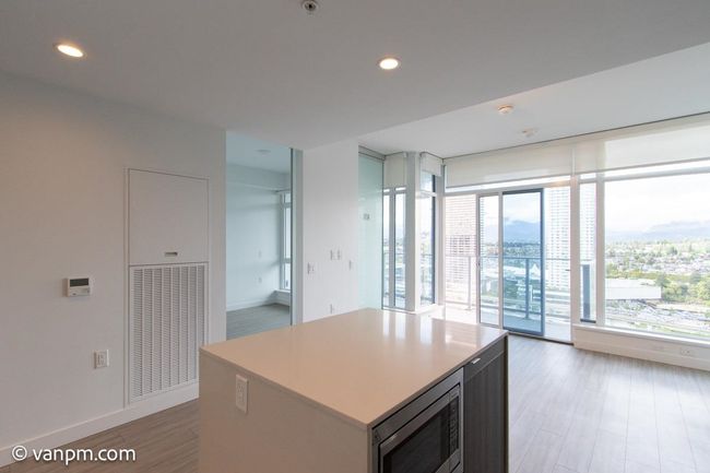 Kitchen with stainless steel microwave, baseboards, light wood-style flooring, recessed lighting, and a kitchen island | Image 13