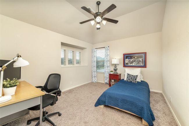 Bedroom featuring carpet, baseboards, an office area, vaulted ceiling, and ceiling fan | Image 29