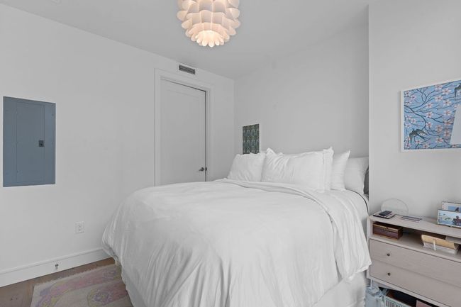 Bedroom featuring electric panel, wood finished floors, and baseboards | Image 16
