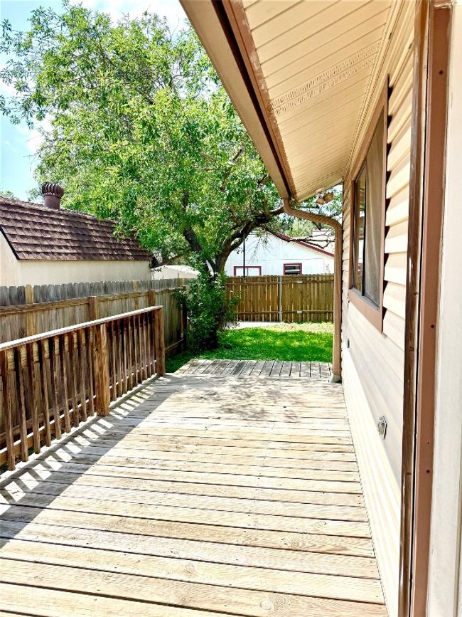 Wooden terrace with a fenced backyard | Image 16