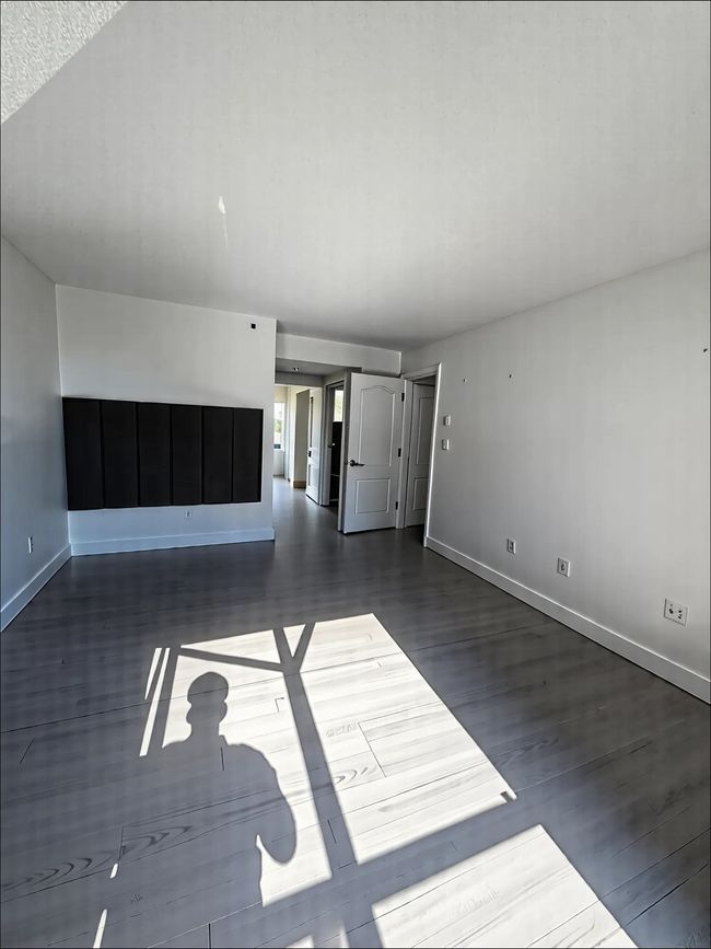 Unfurnished living room with baseboards and wood finished floors | Image 7