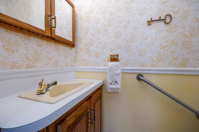 Bathroom with a wainscoted wall, wallpapered walls, and vanity | Image 19