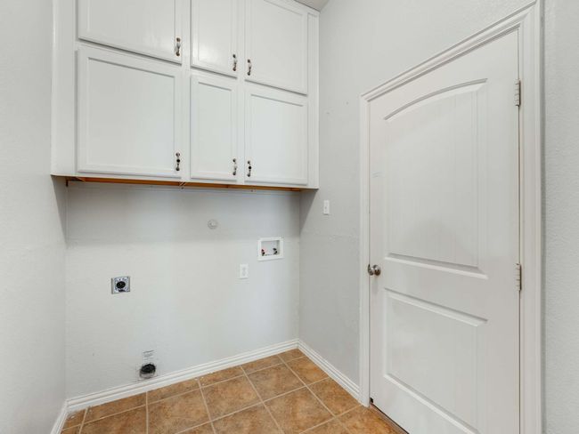 Laundry room featuring electric dryer hookup, cabinet space, washer hookup, gas dryer hookup, and tile patterned flooring | Image 19