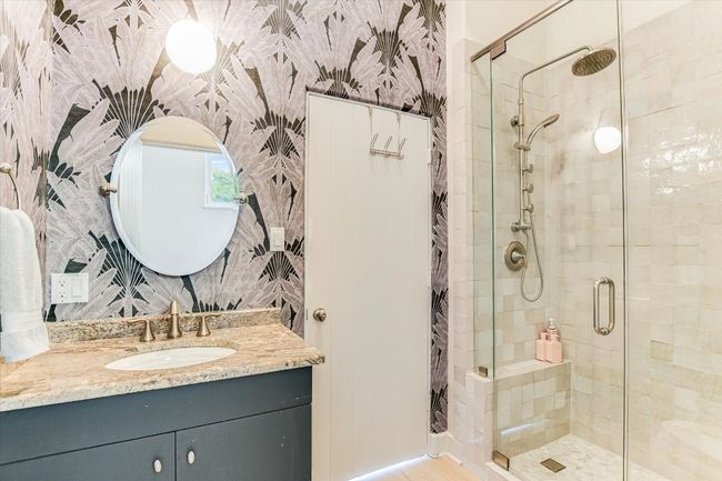 Full bath featuring a shower stall, wallpapered walls, vanity, and wood finished floors | Image 18