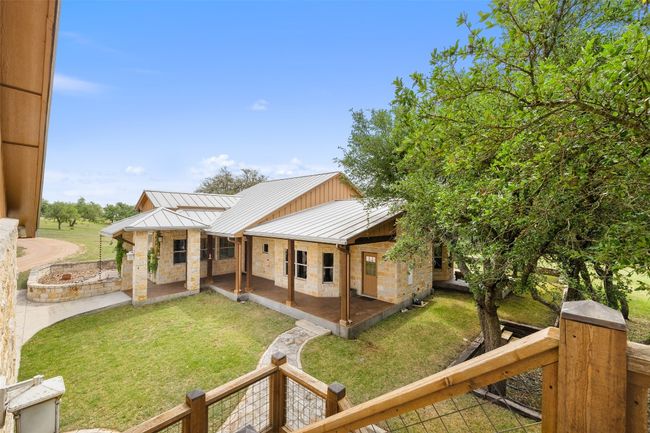 Back of property with a standing seam roof, a yard, metal roof, and stone siding | Image 19