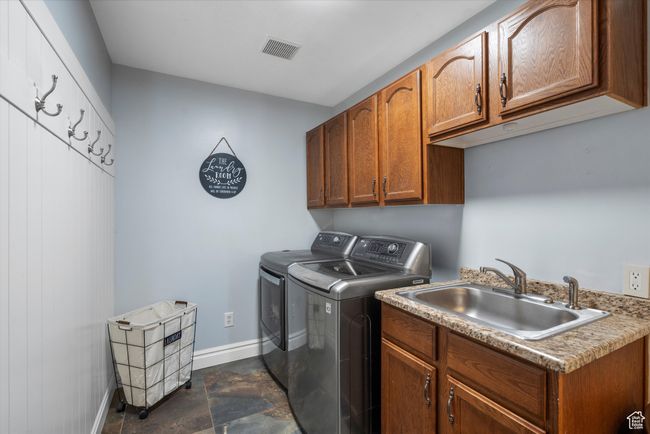 Washroom with washing machine and dryer, a sink, baseboards, visible vents, and cabinet space | Image 13