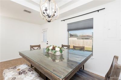 Tiled dining space with electric panel and a notable chandelier | Image 3