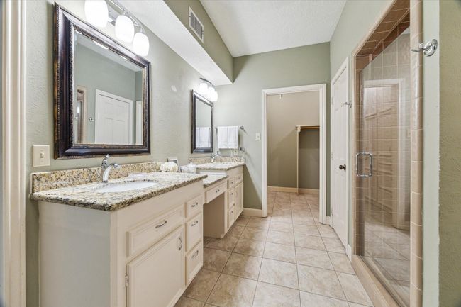 The bath includes a long double sink vanity. The large 9’x6’ primary bedroom closet is just beyond. | Image 21