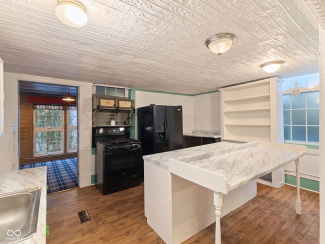 kitchen with open shelves, dark wood-type flooring, a sink, visible vents, and black appliances | Image 10