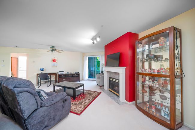 Living area with ceiling fan and a tiled fireplace | Image 18
