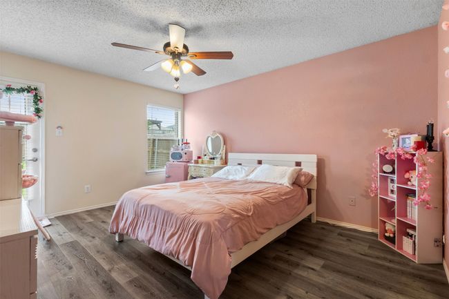 Bedroom with wood finished floors, a textured ceiling, a ceiling fan, and baseboards | Image 17
