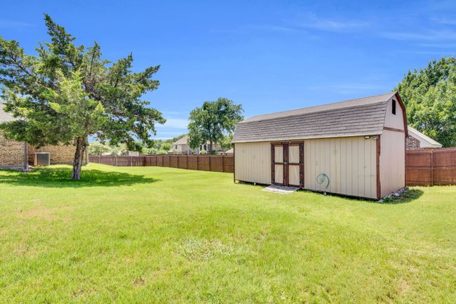 Fenced backyard with a storage shed | Image 35