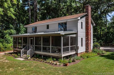 Back of house featuring a sunroom and a lawn | Image 1