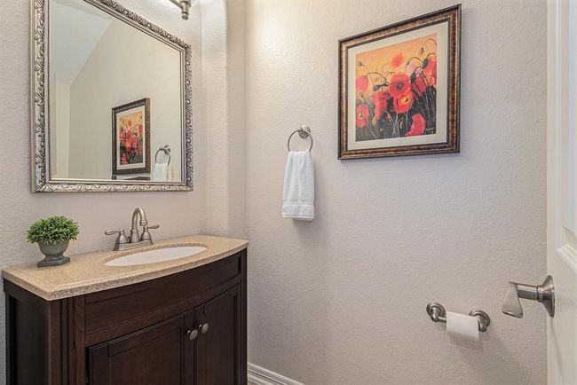 A quaint powder room stands ready for guests to freshen up during a visit! | Image 6