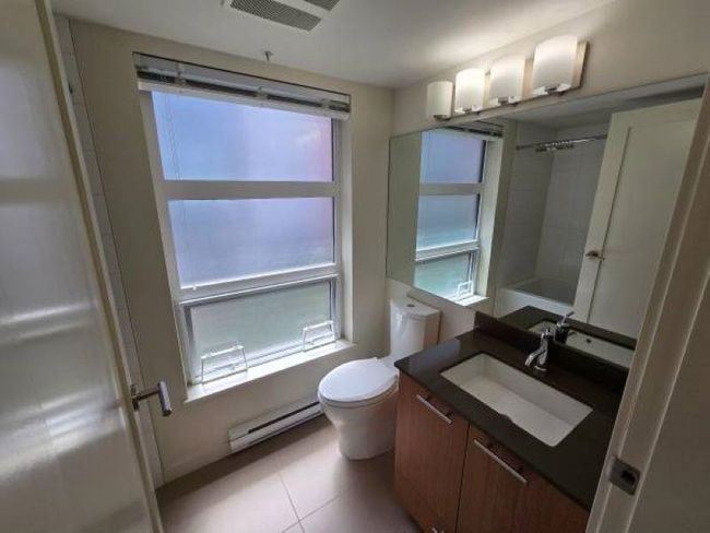 Bathroom with a baseboard radiator, vanity, toilet, and tile patterned flooring | Image 16