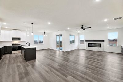 Kitchen with a kitchen island with sink, sink, ceiling fan with notable chandelier, appliances with stainless steel finishes, and dark hardwood / wood-style flooring | Image 2