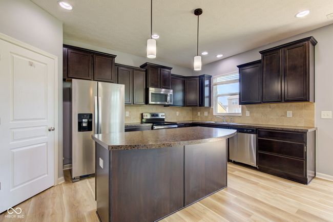 kitchen with stainless steel appliances, dark brown cabinetry, light wood-style flooring, and recessed lighting | Image 7
