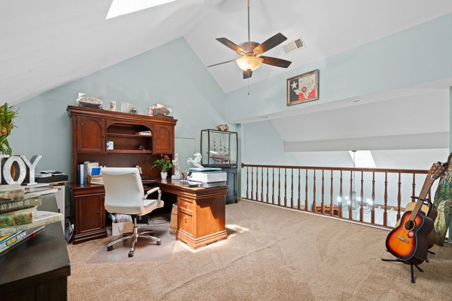 Carpeted office featuring a ceiling fan, a skylight, and high vaulted ceiling | Image 18