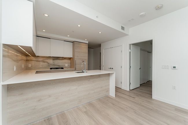 Kitchen featuring a sink, light countertops, decorative backsplash, and modern cabinets | Image 6