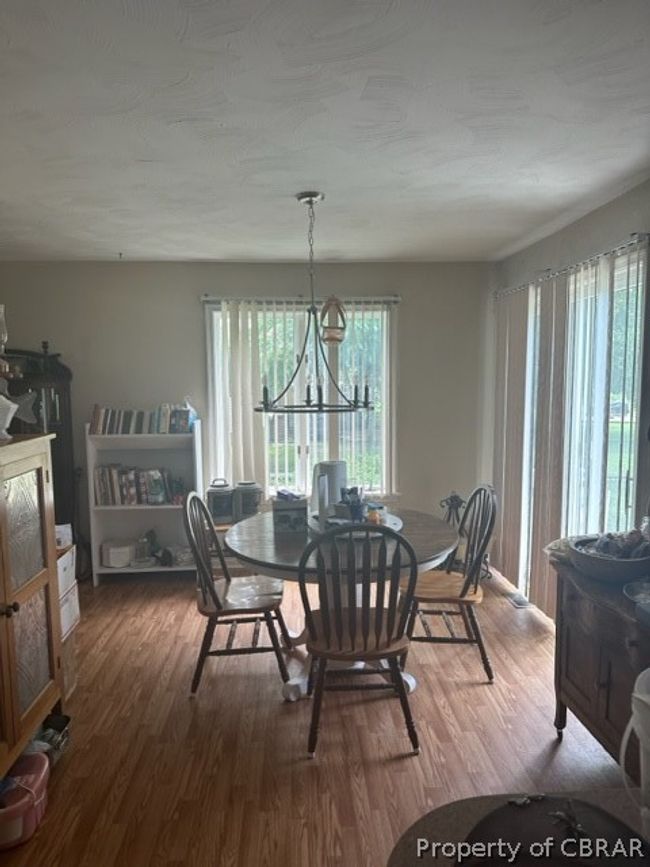 Dining room with wood-type flooring and a chandelier | Image 12