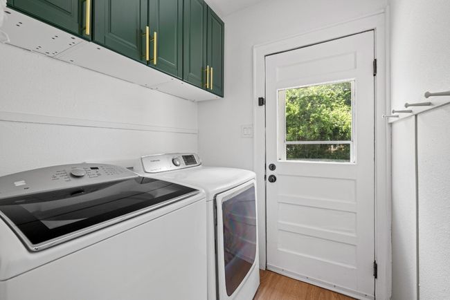 Laundry room with cabinet space, washer and dryer, and light hard wood floors | Image 20
