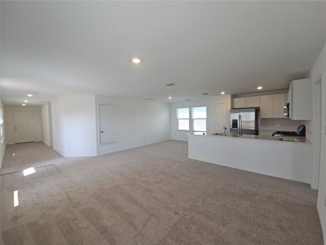 Unfurnished living room with a sink, recessed lighting, and light colored carpet | Image 17