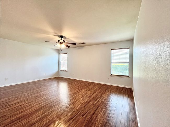 Unfurnished room featuring dark wood-style floors, ceiling fan, and a textured wall | Image 16