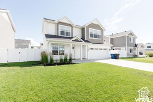 View of front of house with an attached garage, concrete driveway, and a residential view | Image 18