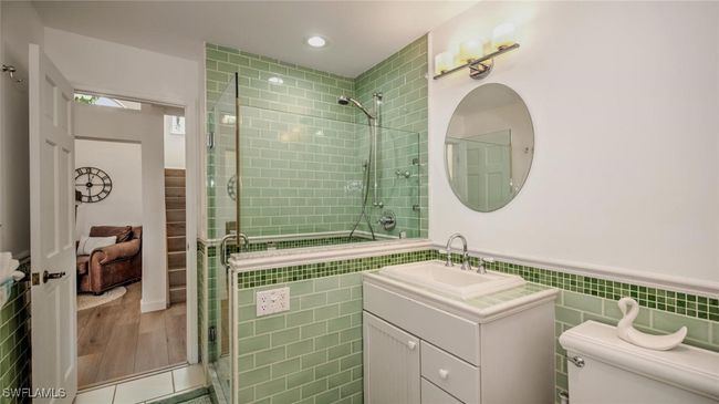 Guest Bathroom downstairs with tile walls, a tile shower, vanity, a wainscoted wall, and recessed lighting | Image 23