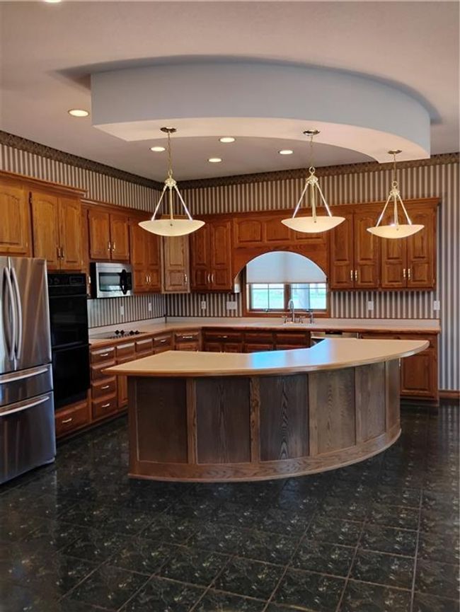 Kitchen featuring a sink, fridge, dishwasher, double wall oven, solid oak cabinetry, and light countertops | Image 28