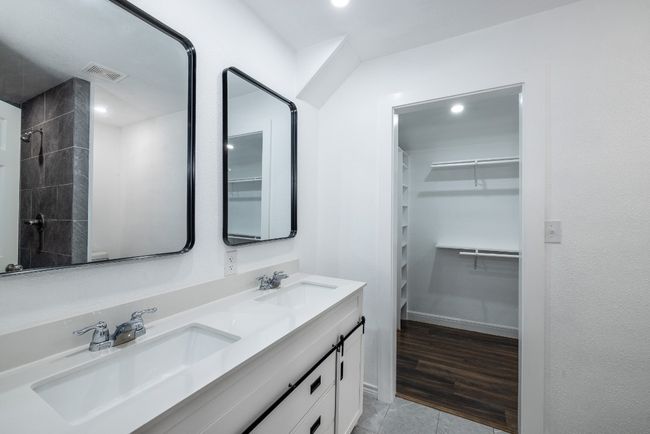 Full bathroom featuring a sink, visible vents, a spacious closet, and double vanity | Image 13