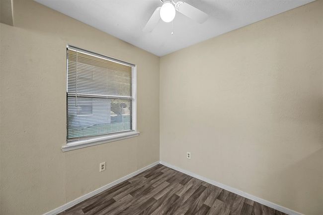 Spare room with dark wood-type flooring and ceiling fan | Image 11