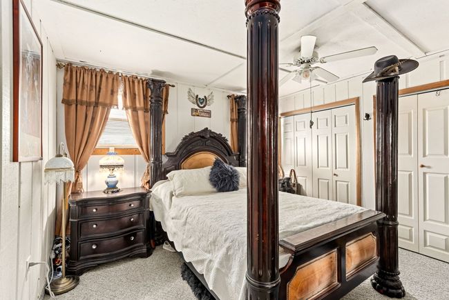 Carpeted bedroom featuring two closets, a ceiling fan, and beamed ceiling | Image 50