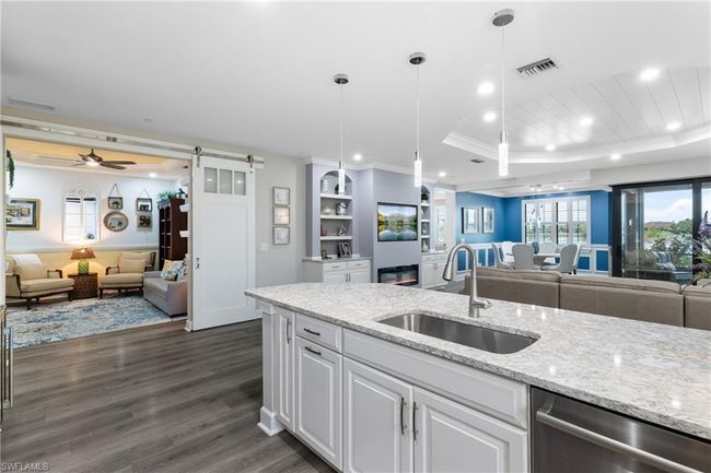 Kitchen with open floor plan, dishwasher, a barn door, recessed lighting, and crown molding | Image 9