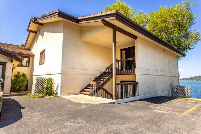 Property entrance featuring a water view, stucco siding, and a patio area | Image 59