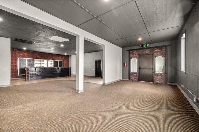 living room featuring brick wall, carpet floors, baseboards, recessed lighting, and arched walkways | Image 41