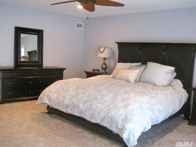 Carpeted bedroom with a ceiling fan | Image 7