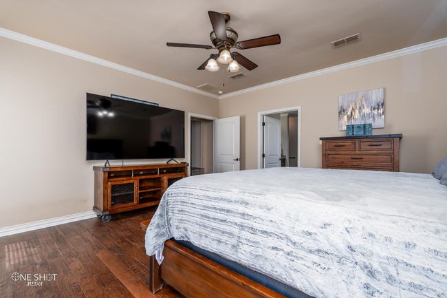 Bedroom featuring ornamental molding, wood finished floors, baseboards, and ceiling fan | Image 21