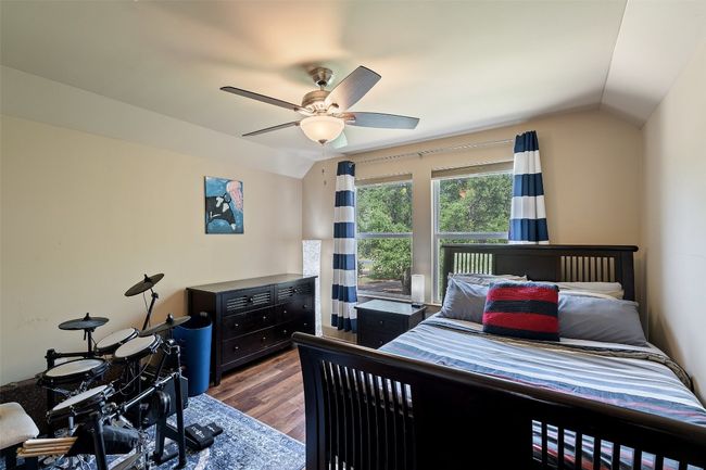 Bedroom with vaulted ceiling, wood finished floors, and a ceiling fan | Image 24