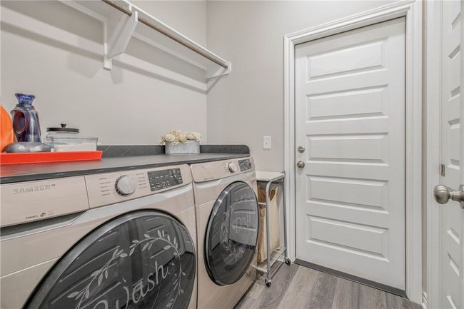 Washroom with washing machine and clothes dryer and wood finished floors | Image 13