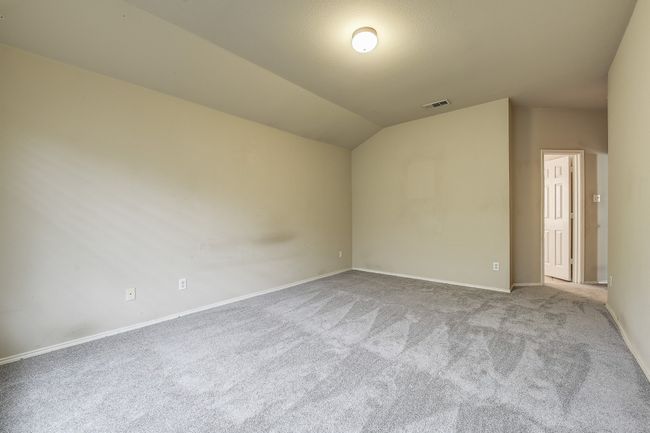 Carpeted spare room featuring lofted ceiling and baseboards | Image 26